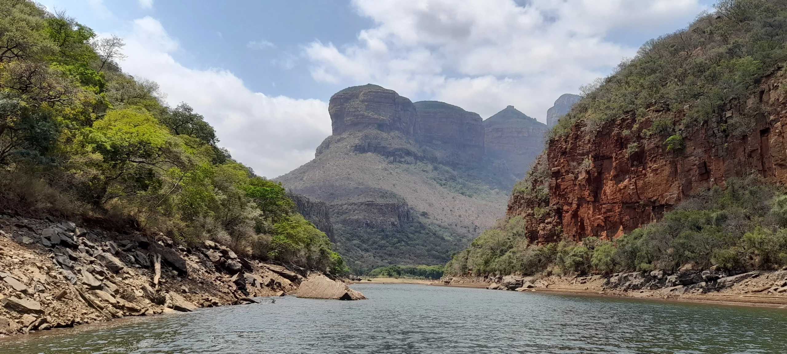 Foto vom Ausblick auf die Three Rondavels aus dem Tal des Blyde River Canyon. Das Foto wurde während einer Bootstour auf dem Blyde River Dam aufgenommen.